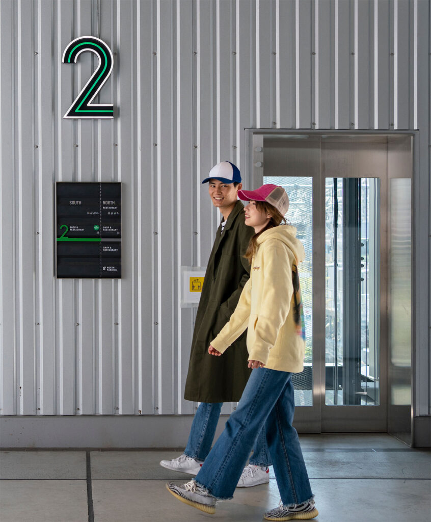Spatial letter and information board - people walking along corridor with signage