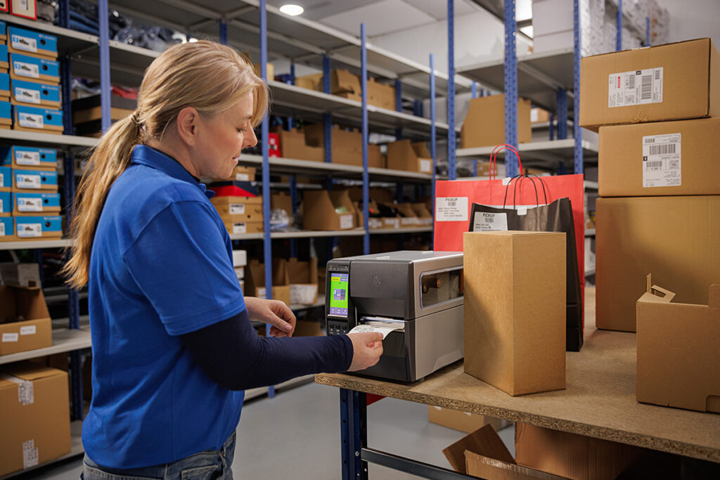 Pracownik magazynu drukuje etykietę za pomocą drukarki etykiet Zebra ZT231