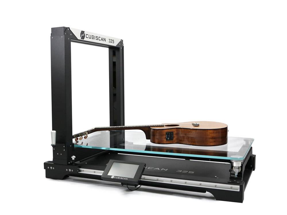 Cubiscan 325 – zdjęcie produktowe urządzenia z gitarą na platformie