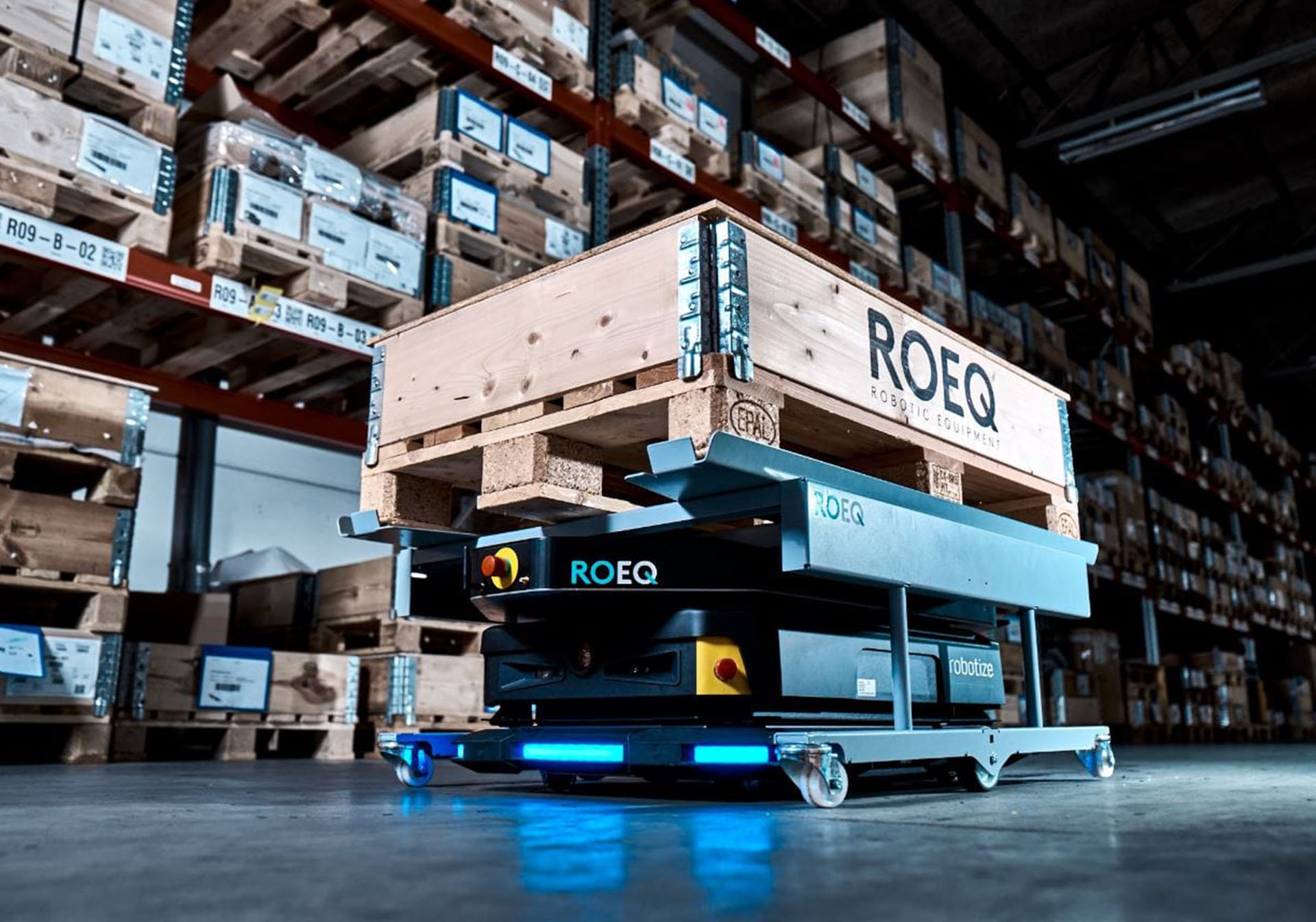 Robot AMR z akcesorium marki ROEQ w magazynie przewożący paletę