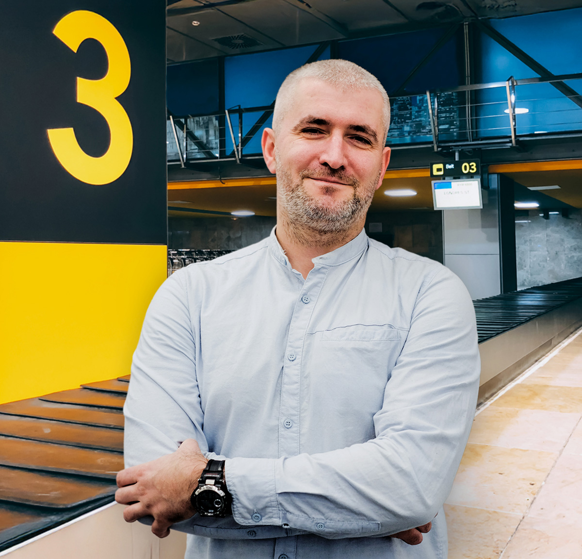 Mężczyzna na tle sortera bagażu na lotnisku