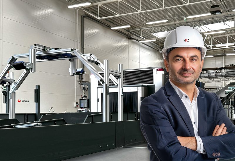 Manager centrum dystrybucji w garniturze i kasku – tło z aktywnym systemem BHS