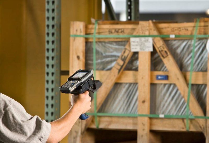 Pracownik magazynu skanuje kod RFID terminalem Honeywell